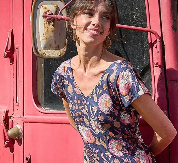 Model met turquoise jasje, geel shirt en broek in turquoise en gele print