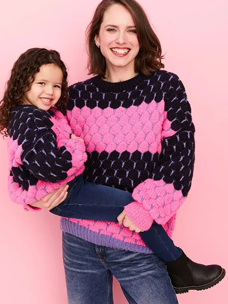 Moeder en dochter dragen trui van Cara & The Sky in dots motief in de kleuren roze en zwart