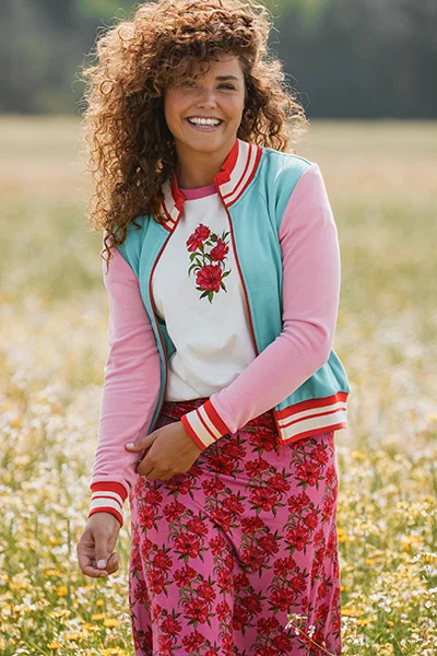 Model met rokje in bloemenprint en bijpassend shirt en kort  jasje