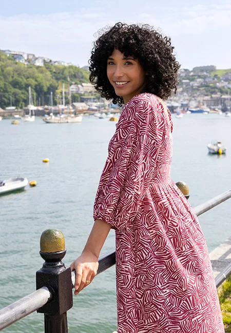 Model met zomerse jurk in rood witte print voor de pagina Over Nomads